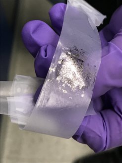 Graphenflocken auf Klebeband. Aus wie vielen Atomschichten sie bestehen, wird unter dem Mikroskop analysiert.