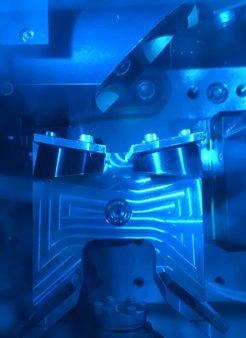 The sample is housed inside a holder (bottom centre), into which the excitation and probing pulses are directed using parabolic mirrors.